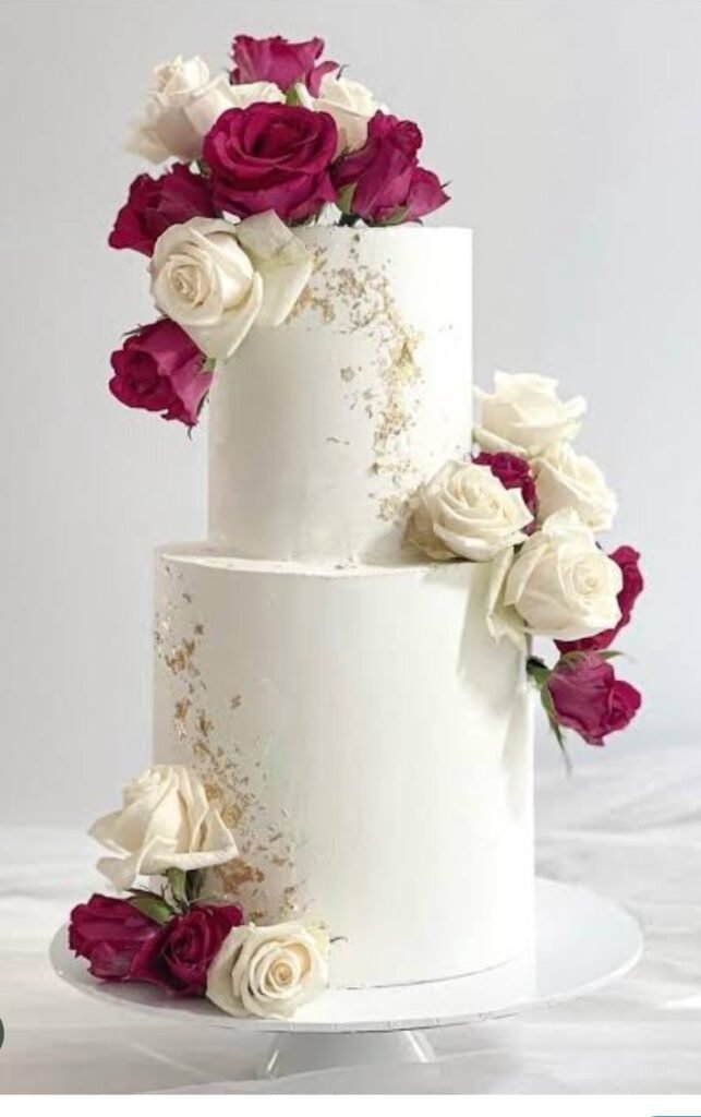 Two tier white cake with red and white flowers