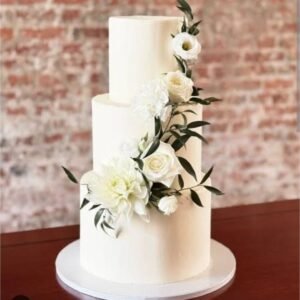 Three tier white cake with flower and leaves