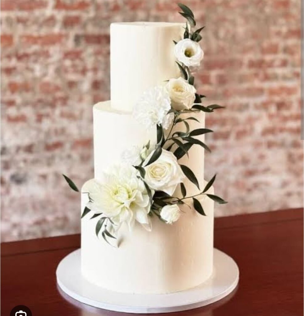 Three tier white cake with flower and leaves