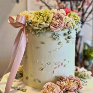 White cake with flowers and pink bow