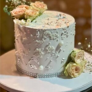 White cake with flowers and pearls