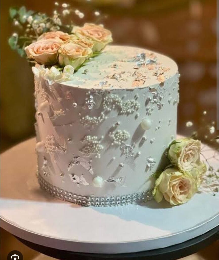 White cake with flowers and pearls