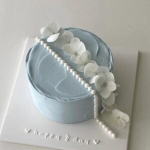 Grey cake with white beads and flower