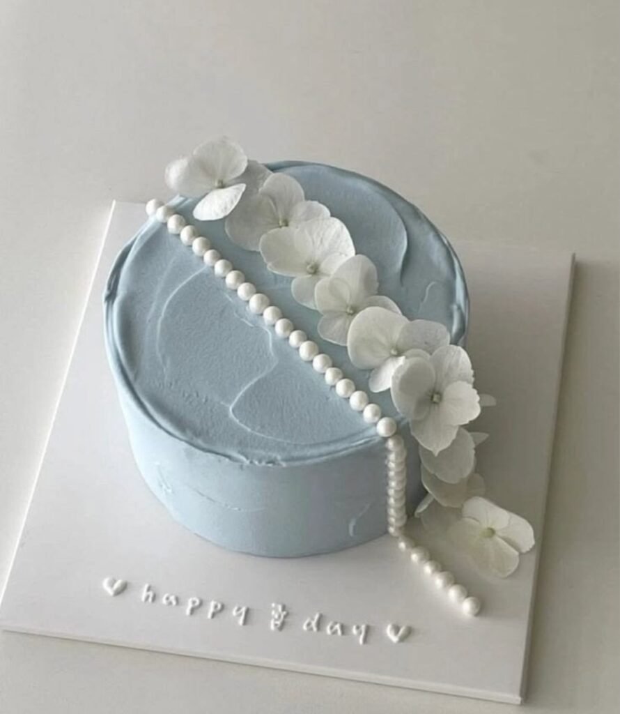 Grey cake with white beads and flower