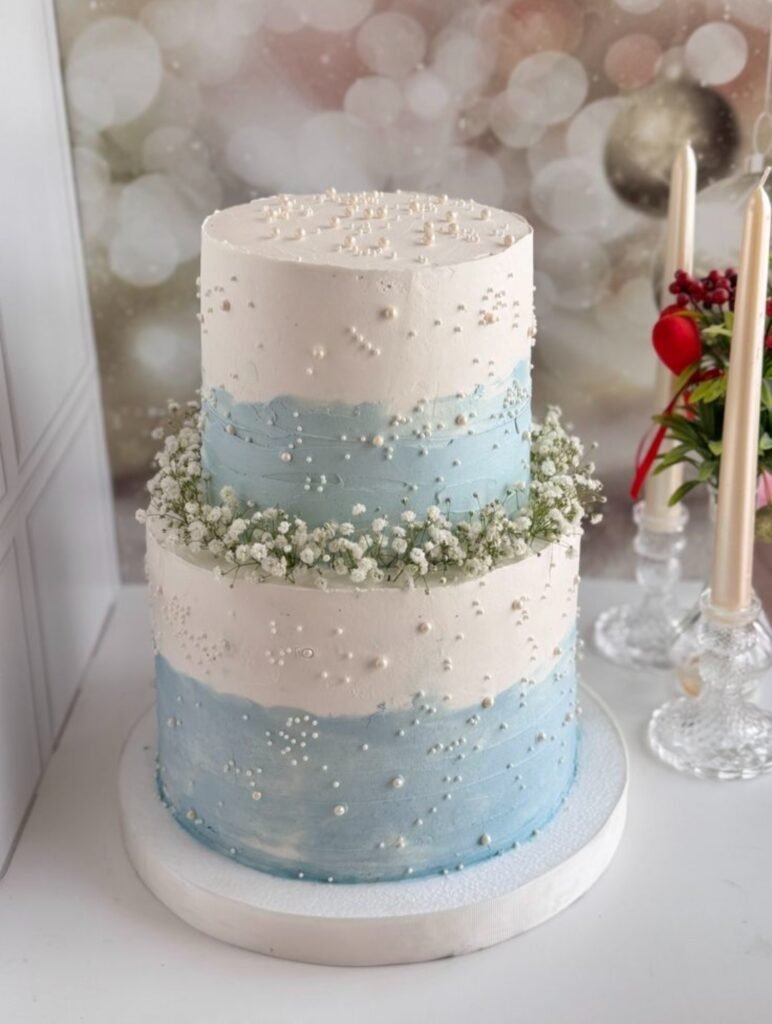 Tall two tier white and light blue themed cake