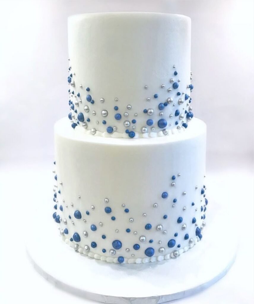 White double tier cake with silver and blue beads