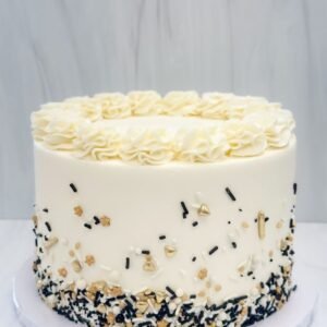 Off white cake with black, golden and white sprinkles