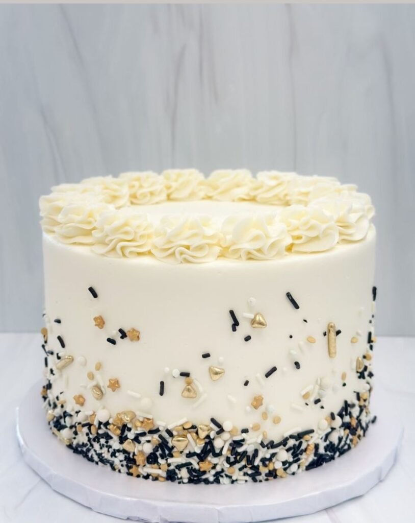 Off white cake with black, golden and white sprinkles