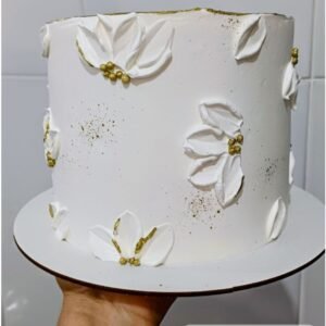 White cream cake with petals and golden beads