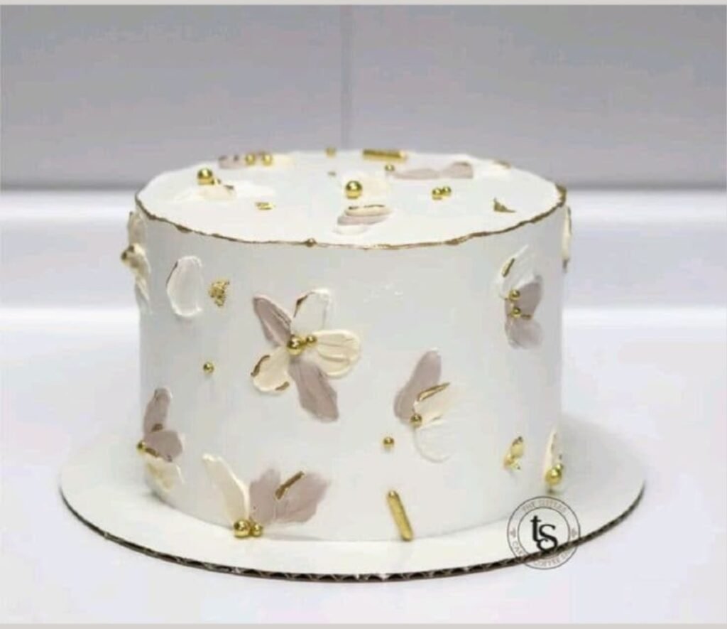 White cake with petals and golden beads