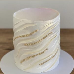 White shiny cake with carvings and pearls