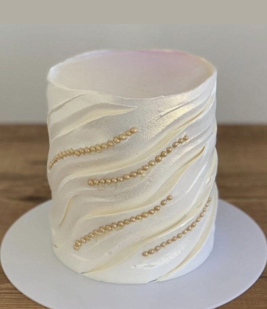 White shiny cake with carvings and pearls